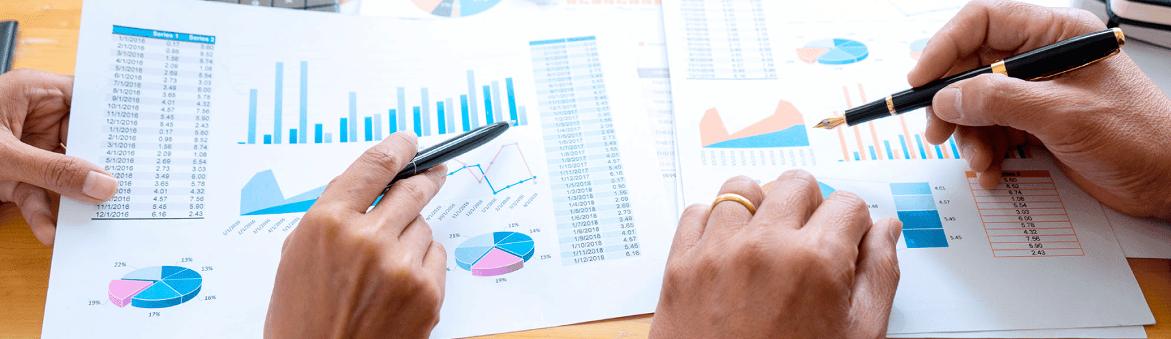 A desk filled with sheets of paper with data graphs as an example of data integrity