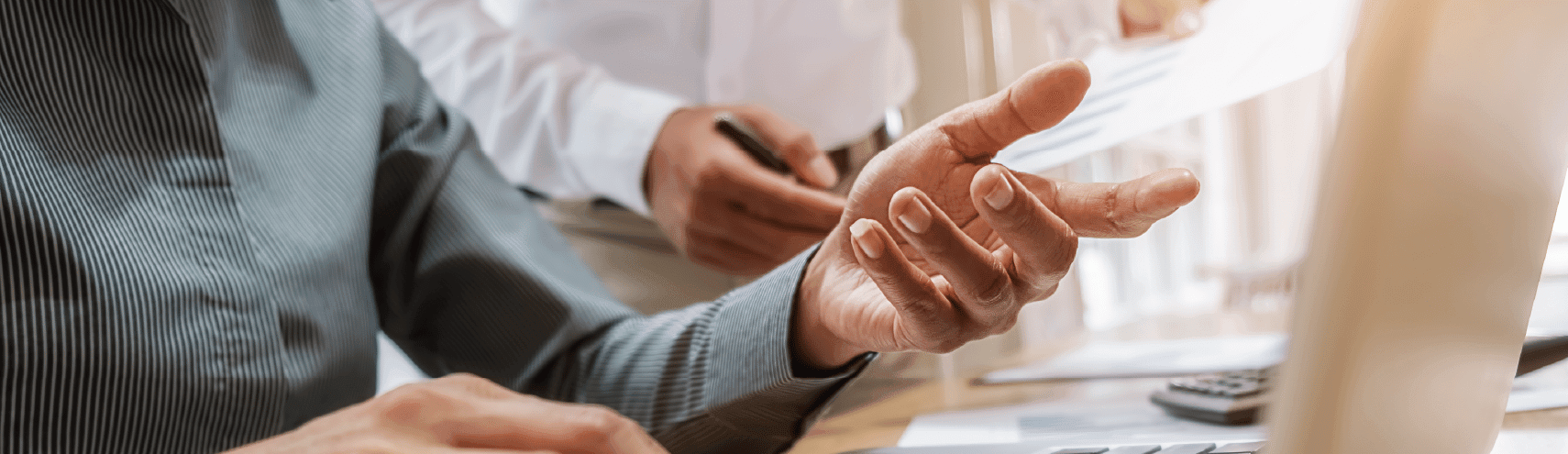 Birds-eye-view of business person using their laptop and taking notes on their desk