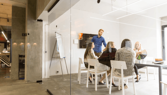 Alation blog image: A group of workers meeting in the office of a startup