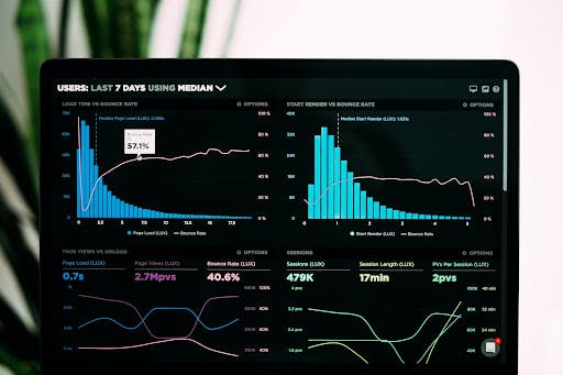 An open laptop screen displaying colorful graphs and charts of data quality metrics against a black background.