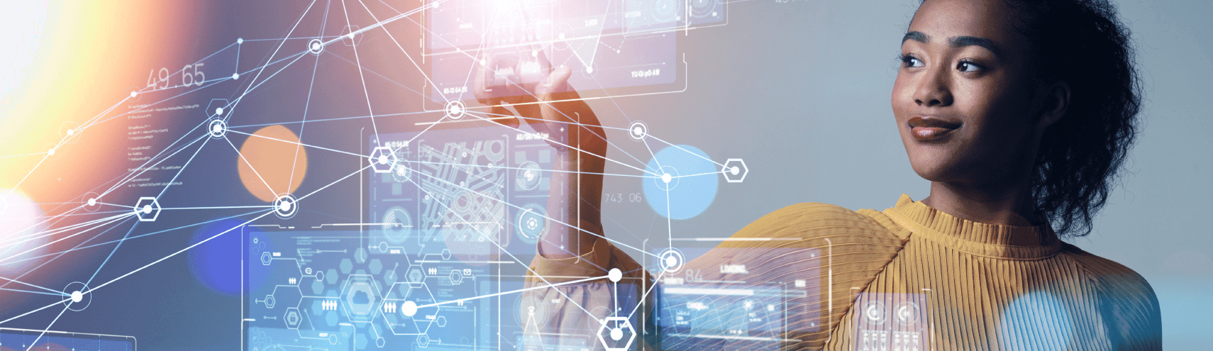 Woman smiling as she points to a touch-screen window with graphs and data interconnected