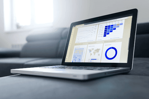 Close-up of a laptop on a couch, showcasing a data analytics dashboard reminiscent of Google Analytics 4.