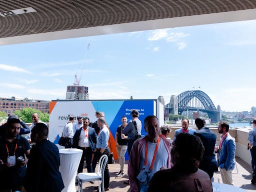 Candid outdoor snapshot capturing Alationauts and partners networking and having a good time at revAlation Sydney 2023.