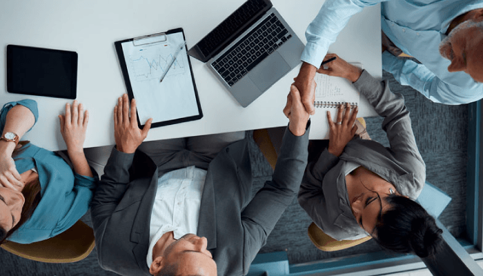 Alation Blog Image: Birds-eye-view of a group of business people working together in an office setting.