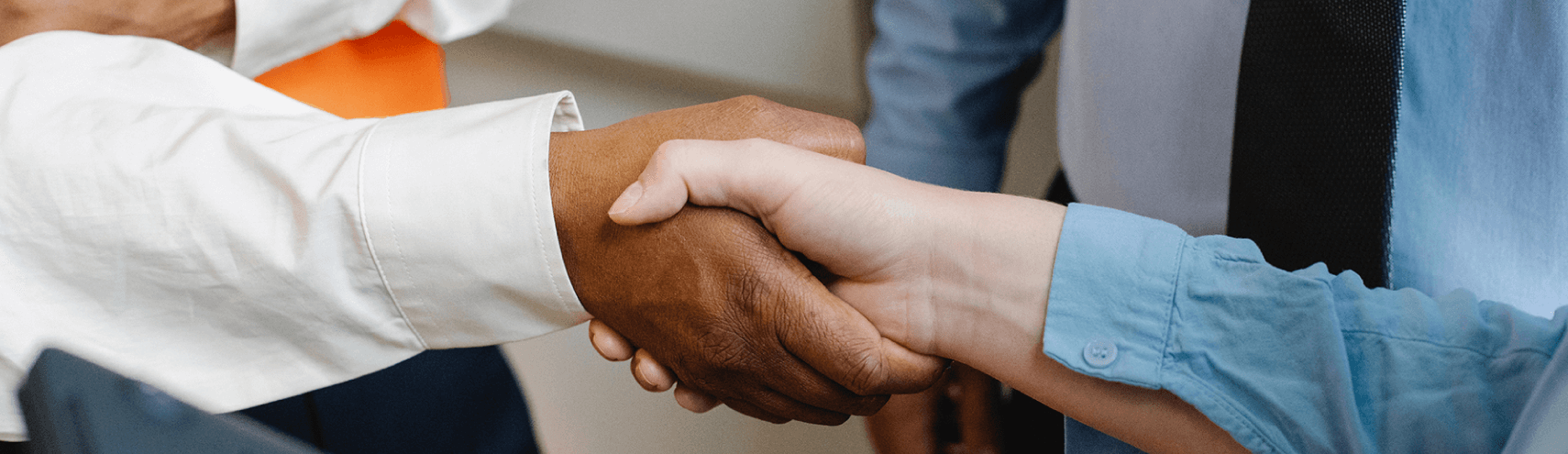 Alation Blog Image: A focused shot of a business handshake taking place.