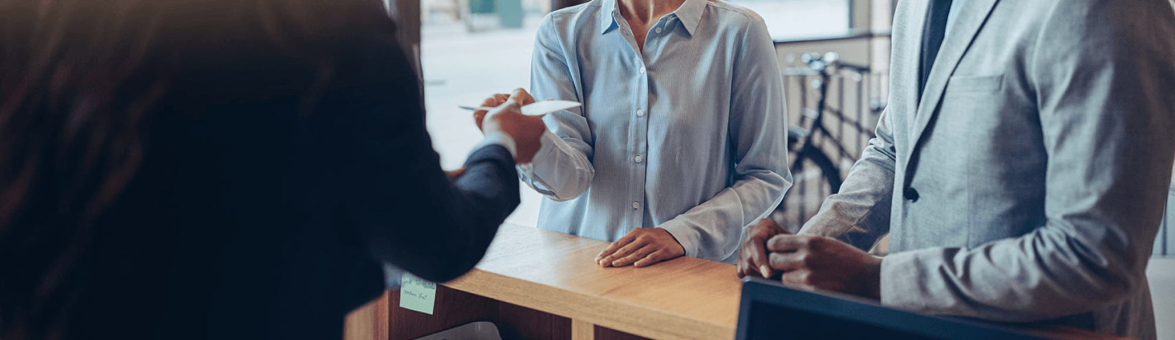 Two data analysts chatting and get information from the front desk of a hospital