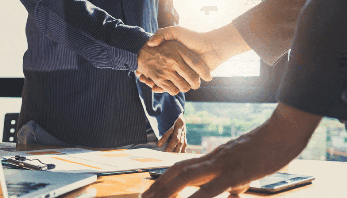 A business handshake between two business people in an office setting
