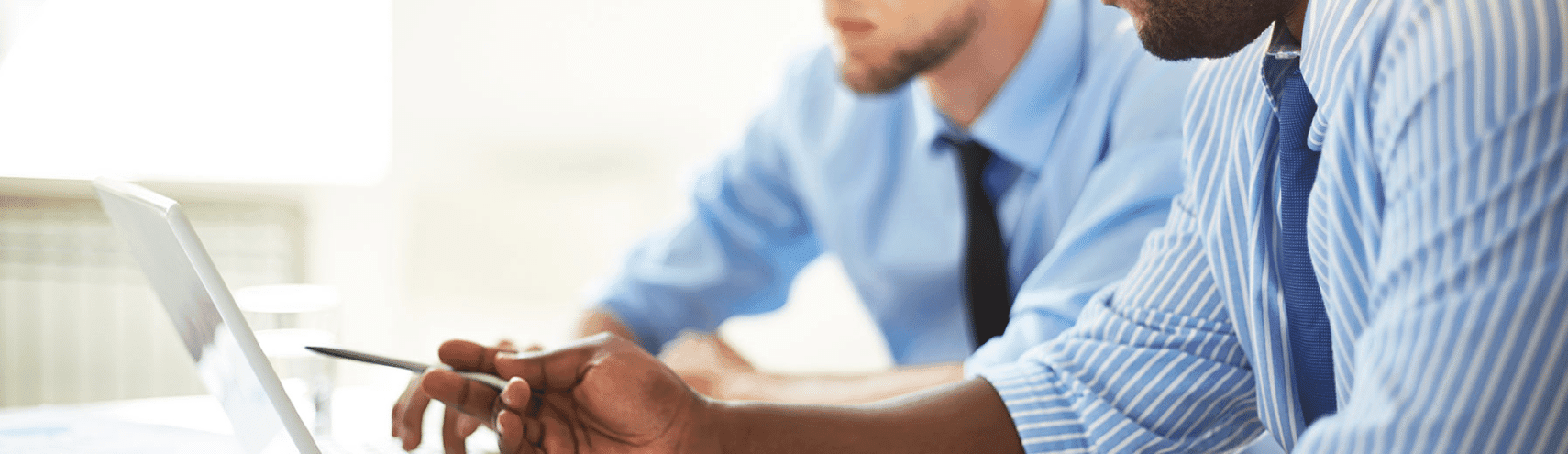 Two business men analyzing why easier governance is superior governance on their laptop