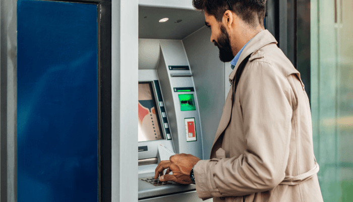 Alation blog image: Man using an ATM for financial transactions to showcase the blog post, "How to Ensure Data Quality in Financial Services"
