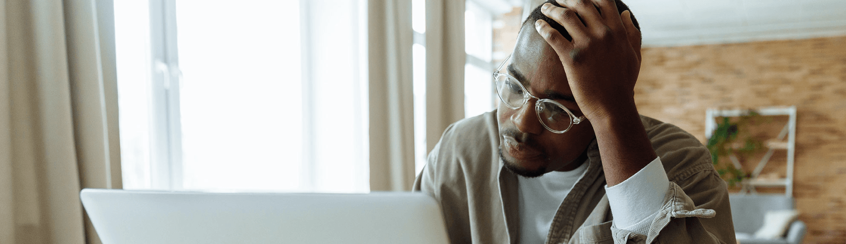 A confused reader reading about the 5 data governance mistakes on his laptop