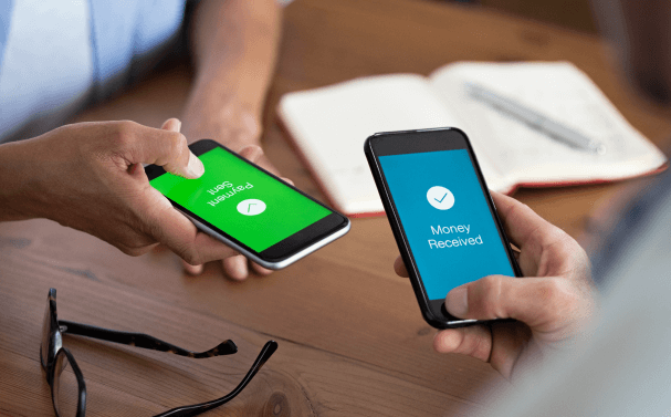 Two people transact money using their mobile phones