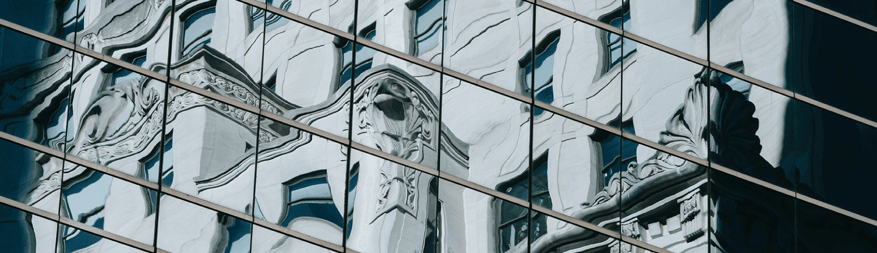 Reflective window from a public sector building showing the reflection of another building in the city