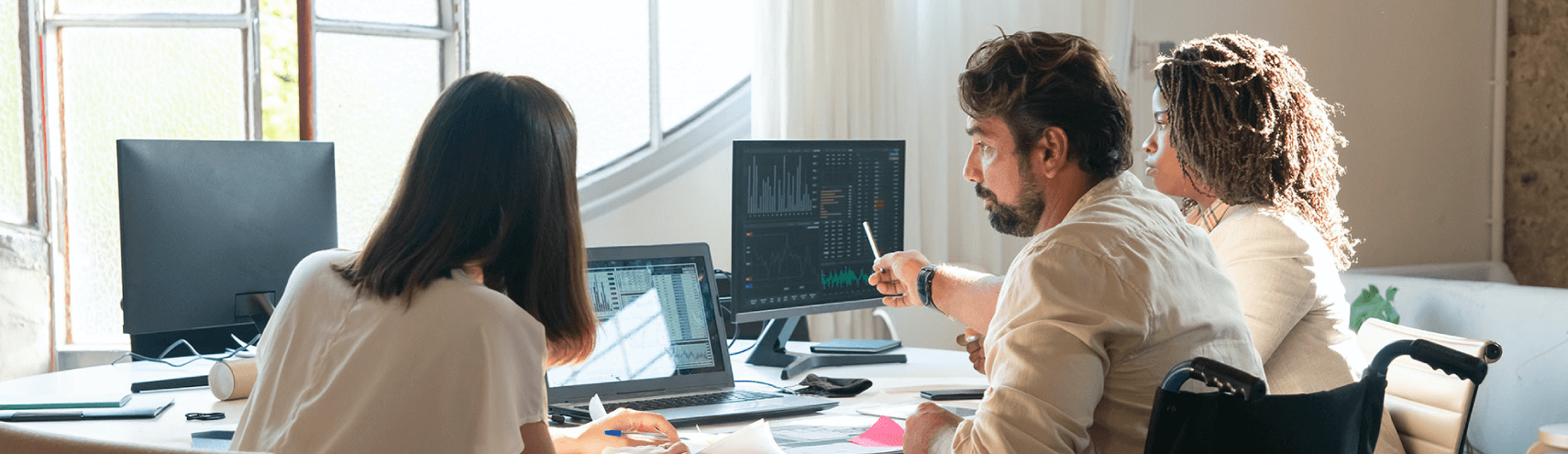 Alation Blog Image: A group of business leaders working together in an office setting looking into data-driven decision making.