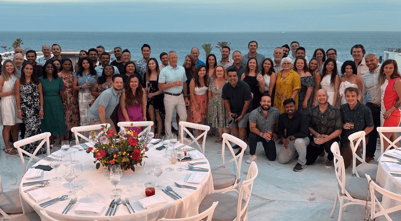 Group photo of the Alation Achievers Club in front of the ocean