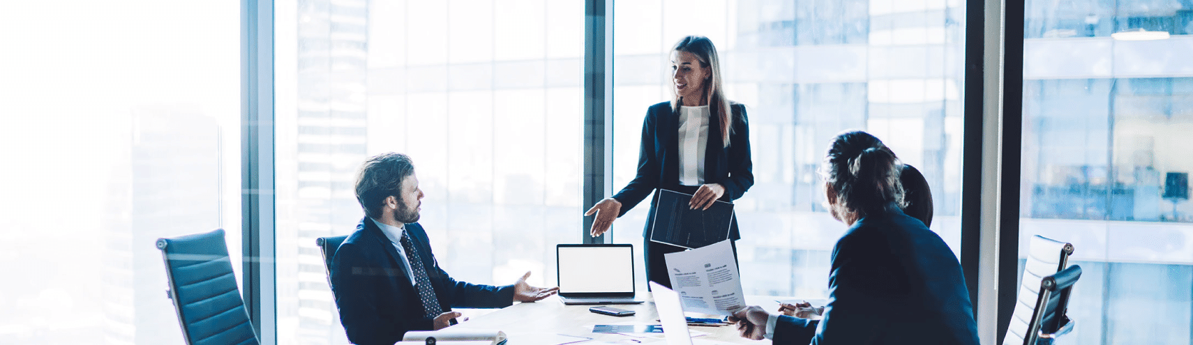 Business woman meeting with her team going over data governance supporting analytics in an office setting