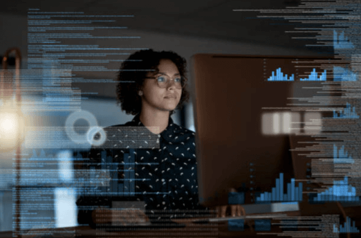 Woman working at a computer with data, graphs, etc. 