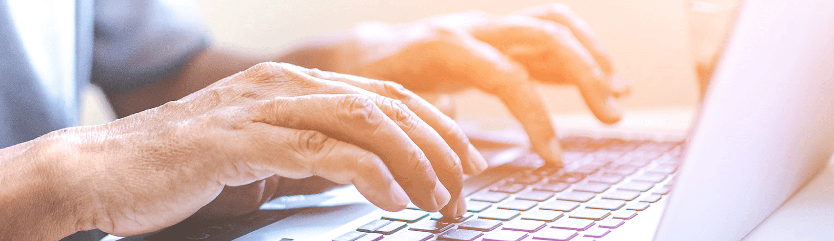 Two hands typing on an opened laptop