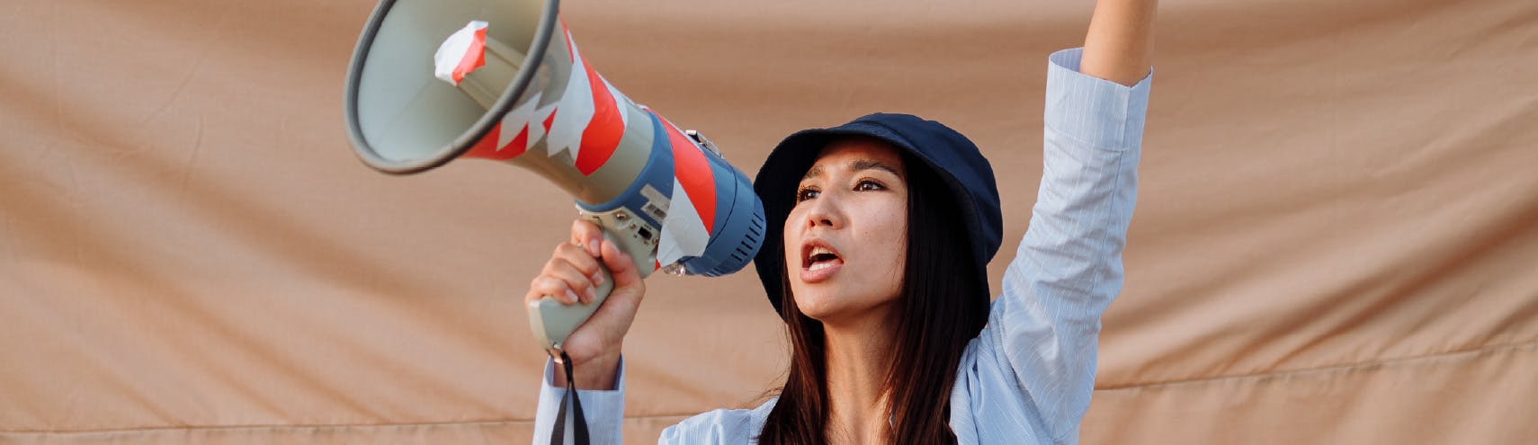 Woman holding a megaphone with one hand raising her other hand up as she shouts, "Long Live the Spreadsheet!"