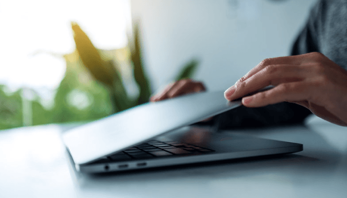 Alation Blog Image: Hands opening up a laptop on a desk.