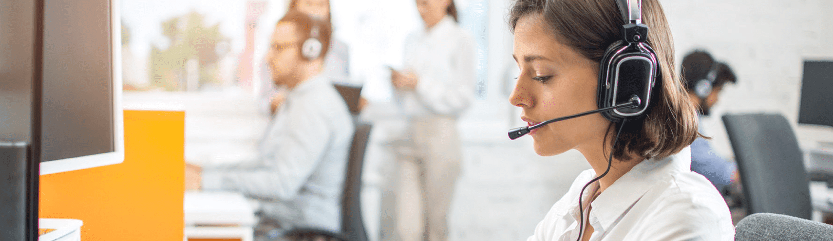 Woman wearing a microphone headpiece in an office setting