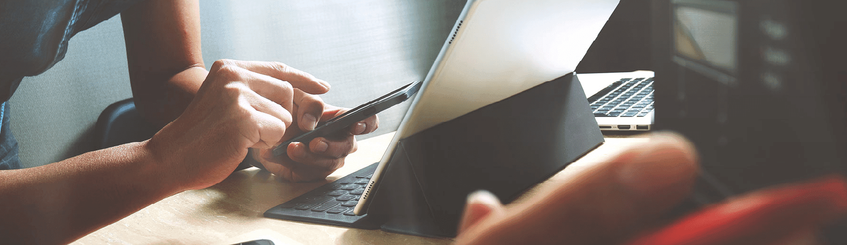 Opened Ipad with stand while someone is also texting on their iphone