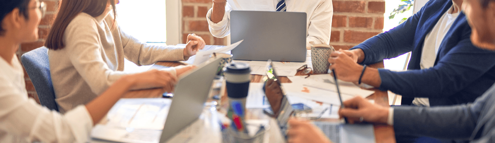 Alation Blog Image: Group of business leaders discussing what is the true value of a data catalog in a meeting room.