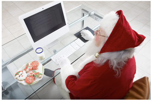 Birds-eye-view of Santa sitting down on his work desk using Alation's trust flags as he checks out if his data has been naughty or nice.