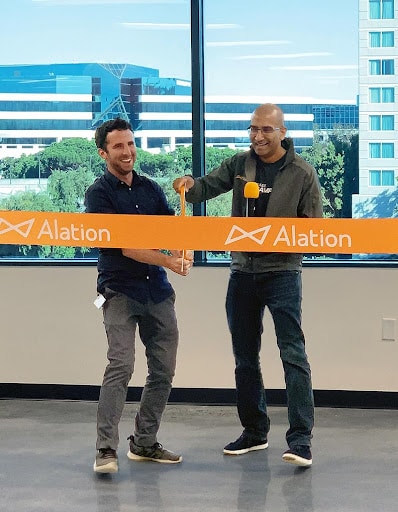 Satyen Sangani, CEO, and Aaron Kalb, CDAO, cutting an Alation banner at the office opening.
